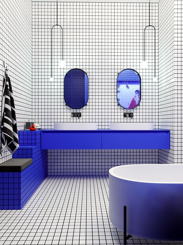 a blue and white bathroom with two round mirrors