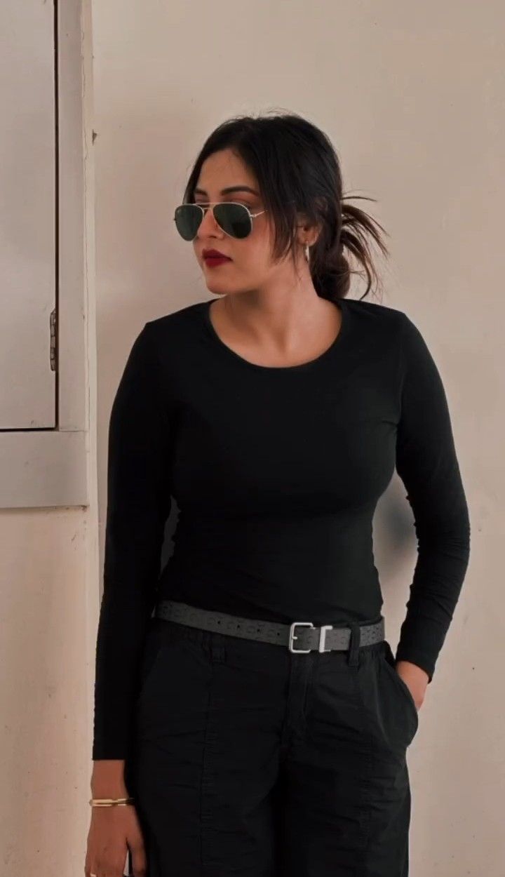 a woman in black shirt and pants with sunglasses on