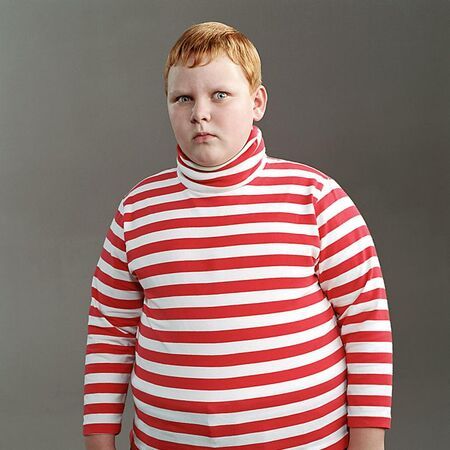 a man in a red and white striped shirt with his hands on his hips looking at the camera