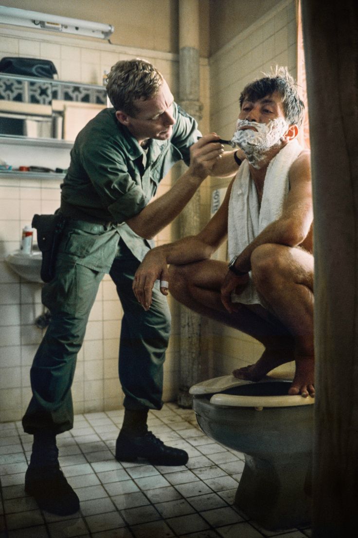 two men shaving each other in a bathroom