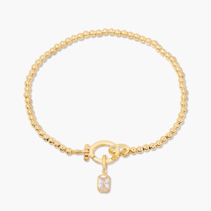 Treat your wrists to some bling with the Mackenzie Birthstone Bracelet. With a vivid birthstone charm, and intricately-beaded gold, this sparkling accessory is sure to add a touch of glam to any outfit. Avery Bracelet: Available in 14k gold plated or rhodium plated brass, 6" bead bracelet, hinge closure measures 1/2", 4mm beads Mackenzie Hinge Birthstone Charm: Available in 14k gold plated sterling silver or rhodium plated sterling silver1/8"x1/4" charm, 5mm Cubic Zirconia NOTE - open bracelet h Elegant Jeweled Beaded Bracelets For Gift, Elegant Adjustable Crystal Bracelet With Charms, Elegant Adjustable Crystal Charm Bracelet, Gold Beaded Bracelets With Sparkling Stones As Gift, Gold Crystal Bracelet With Jewels, Adjustable, Adjustable Gold Crystal Bracelet With Jewels, Gold Charm Bracelet With Cubic Zirconia, Gold Cubic Zirconia Bracelet With Charms, Gold Cubic Zirconia Charms Bracelets