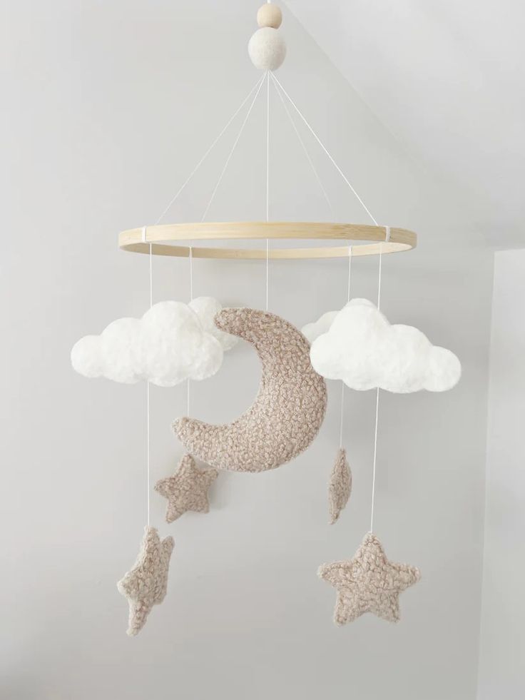 a crib mobile with stars and clouds hanging from it