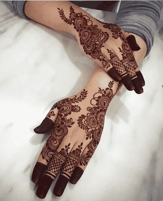 a woman's hands with henna tattoos on them