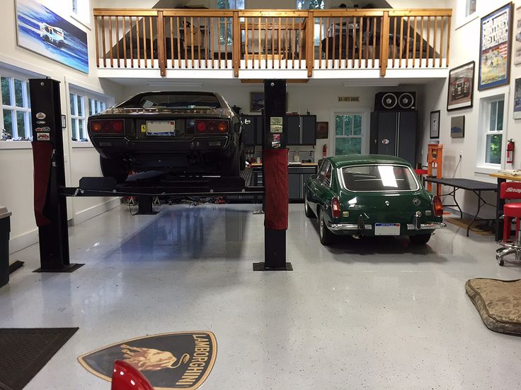 two cars are parked in the garage next to each other and there is a staircase above them