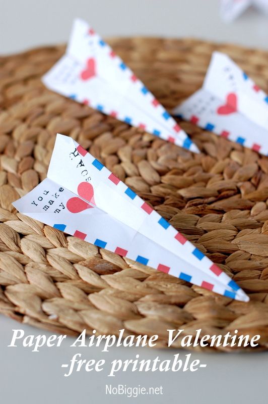 two paper airplanes sitting on top of a woven basket