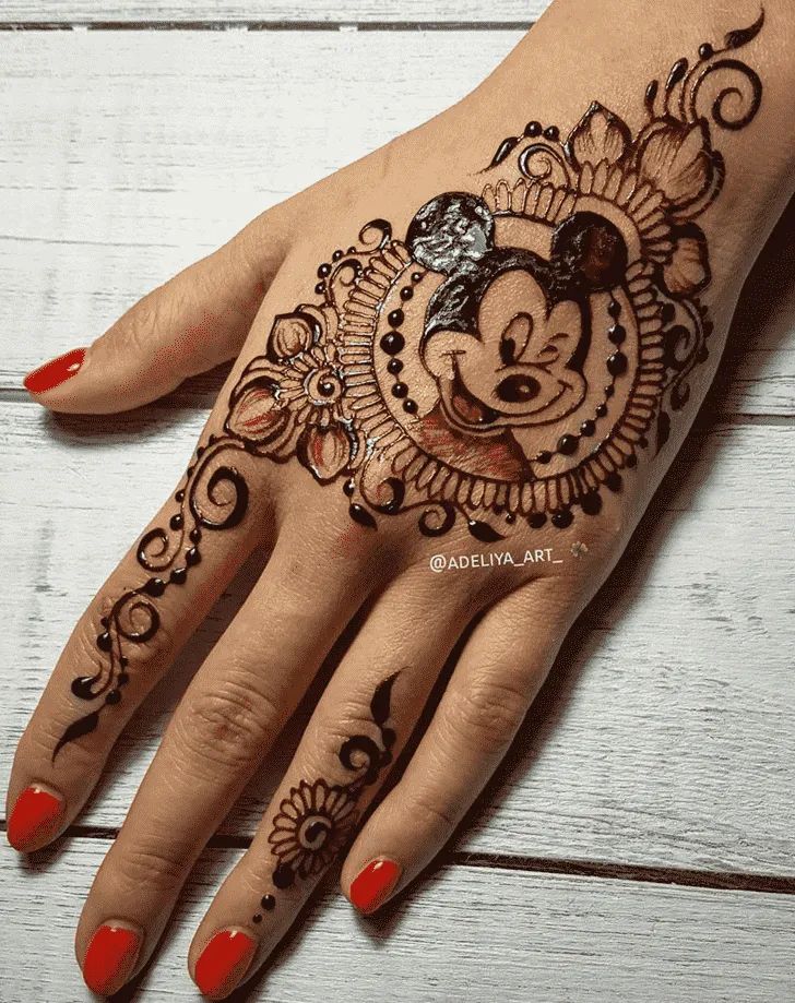 a woman's hand with a mickey mouse tattoo on it