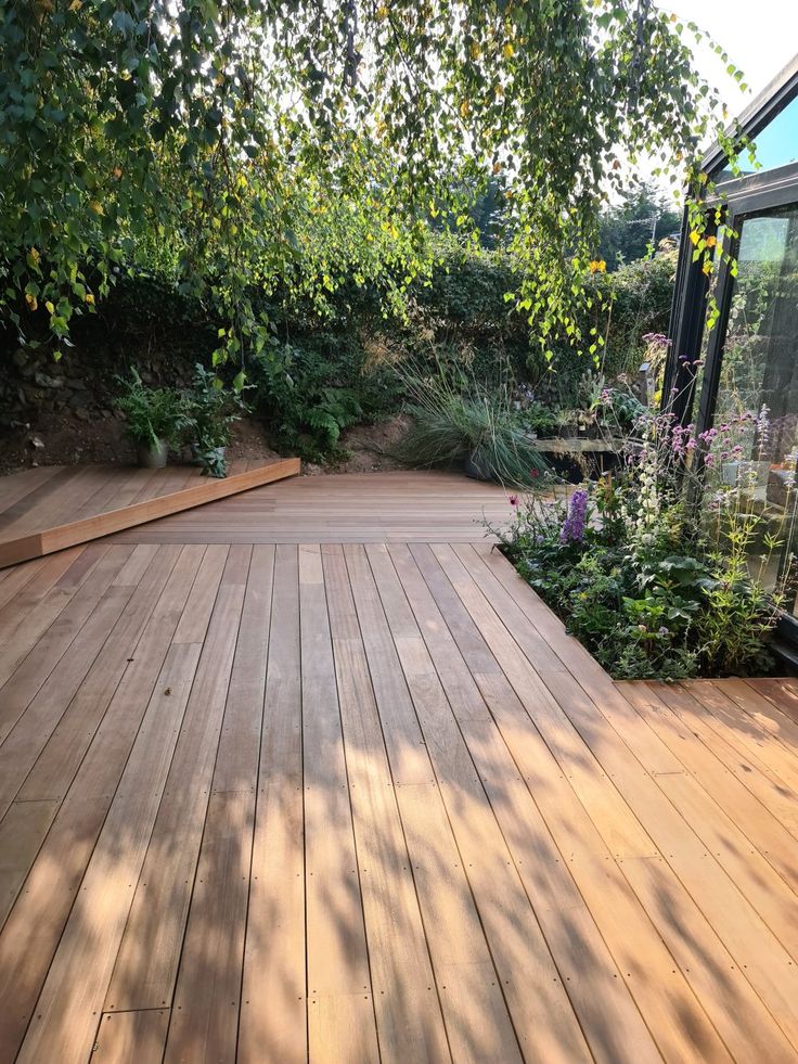 a wooden deck surrounded by trees and plants