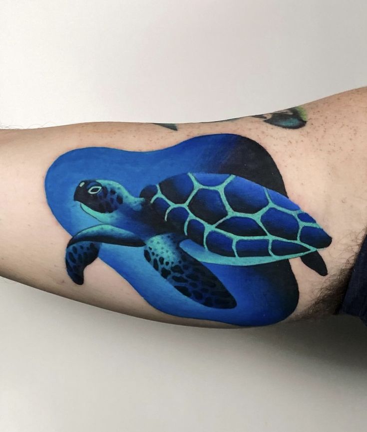 a man's arm with a tattoo of a turtle on the inside of it