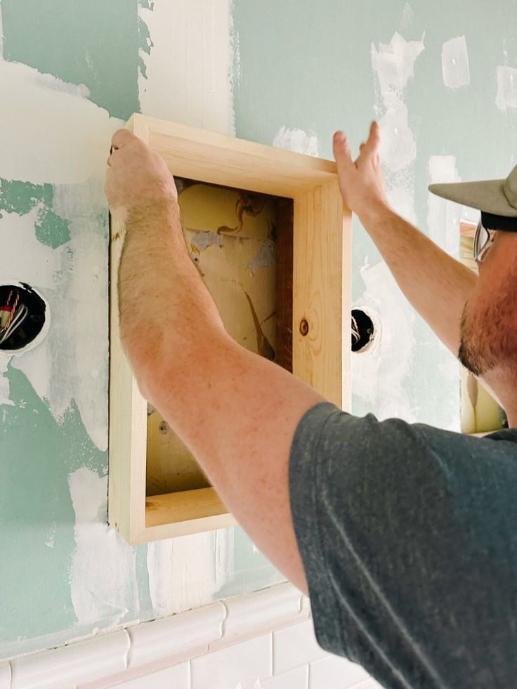 a man is working on the wall in his home