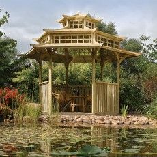 a wooden gazebo sitting in the middle of a pond