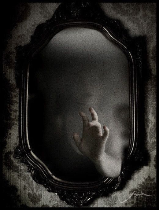 a hand reaching out from behind a mirror