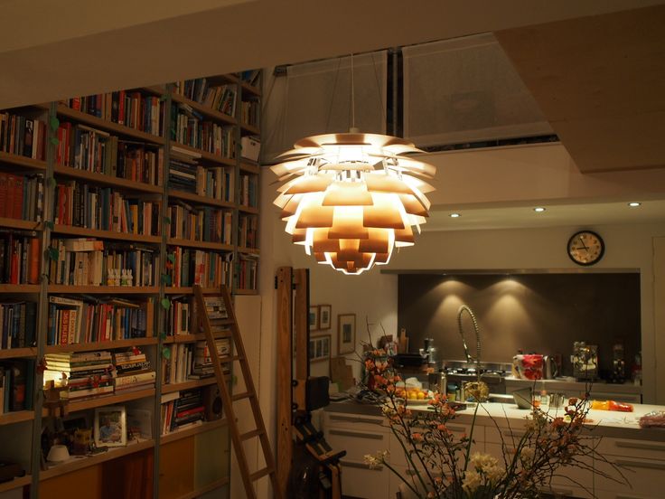 a room filled with lots of books and a ladder in front of a book shelf