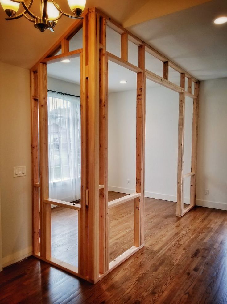 an empty room with wooden floors and glass doors