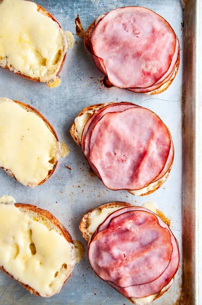 ham and cheese sandwiches are on a baking sheet, ready to be baked in the oven