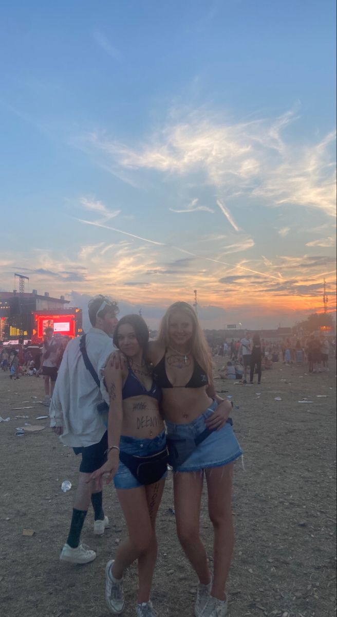 two women standing next to each other in front of a crowd at a music festival