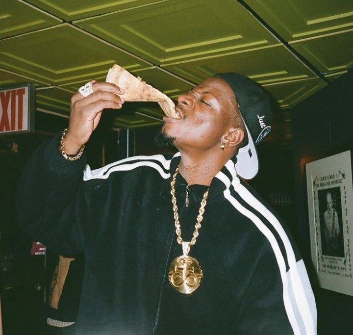 a man eating a piece of food while wearing a hat