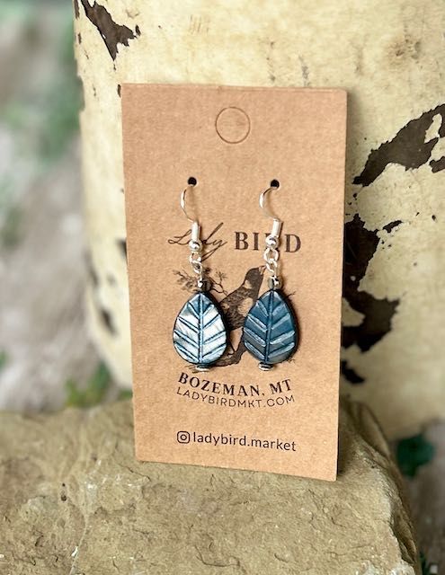 Add a touch of nature, whimsy, and craftsmanship to your jewelry collection with our blue etched glass leaf design earrings. These exquisite beads are meticulously crafted in the Czech Republic, known for its centuries-old glassmaking tradition. Each bead features intricate etching that creates a textured, frosted look, adding depth and character to your pendant earrings. Ideal for pendant earrings, these lightweight beads are easy to work with, offering a refined, vintage-inspired aesthetic tha Etched Blue Jewelry For Gift, Etched Metal Dangle Earrings, Blue Leaf-shaped Jewelry Gift, Bohemian Etched Metal Earrings, Blue Leaf-shaped Jewelry For Gift, Bohemian Etched Dangle Earrings, Vintage Etched Drop Earrings, Blue Nature-inspired Drop Earrings, Nickel-free Leaf-shaped Nature-inspired Jewelry