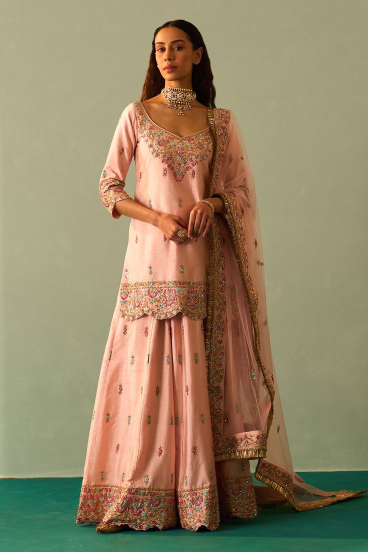 Pink kurta embroidered in traditional zardozi using resham cutdana, dabka and sequins. Paired with fringe dupatta and embroidered sharara.
Component: 3
Pattern: Embroidered
Type Of Work: Zardozi
Neckline: Leaf
Sleeve Type: Long
Fabric: Raw Silk, Lining: Crepe
Color: Pink
Other Details: 
Floral pattern
Embroidered sharara and dupatta
Scallop border
Back tassel tie-up kurta
Occasion: Wedding,Bride - Aza Fashions Fringe Dupatta, Pink Sharara, Leaf Sleeve, Embroidered Sharara, Pink Anarkali, Kurta Sharara Set, Pink Kurta, Kurta Sharara, Scallop Border