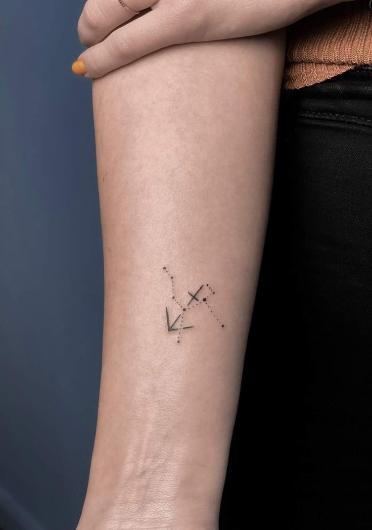 a woman's arm with a small star tattoo on the left side of her arm