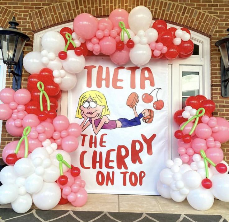 there is a sign that says the cherry on top in front of balloons and lights