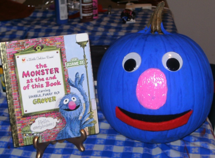 a blue pumpkin sitting on top of a table next to a children's book