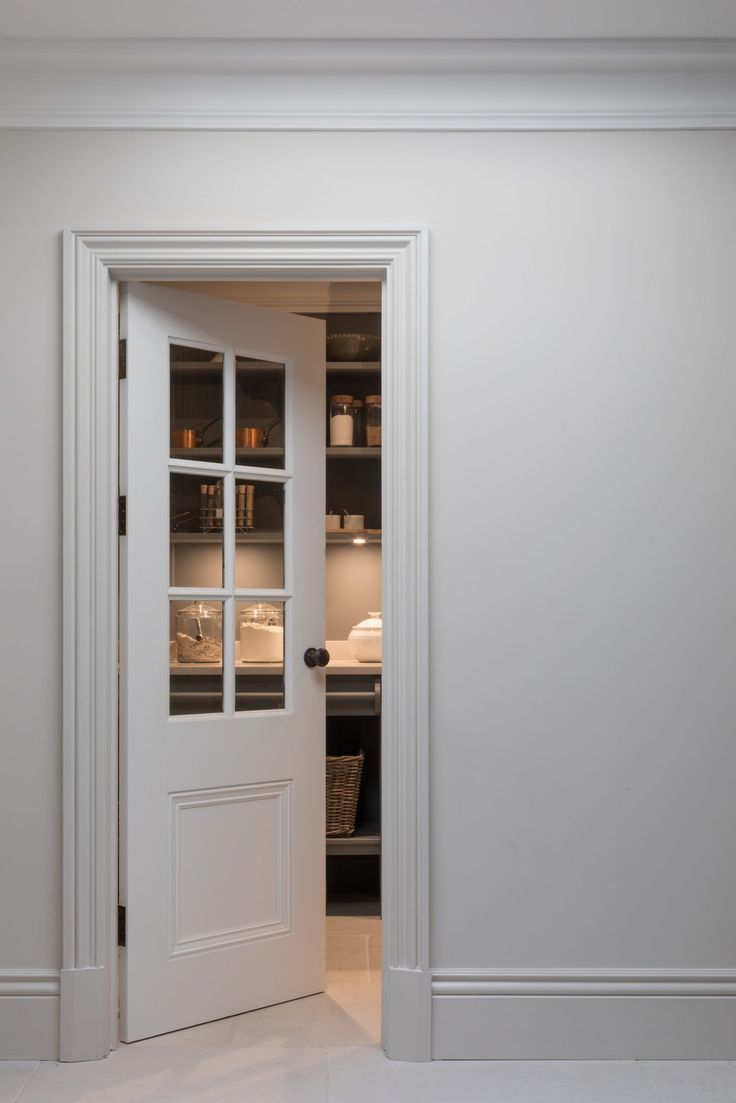 an open door leading into a kitchen with white walls