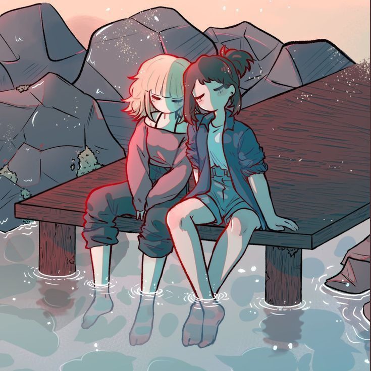 two people sitting on a bench in the water