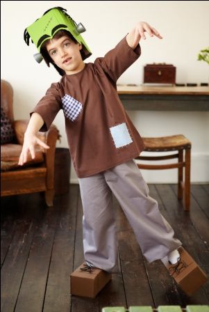 a young boy wearing a paper hat and standing on blocks in front of a chair