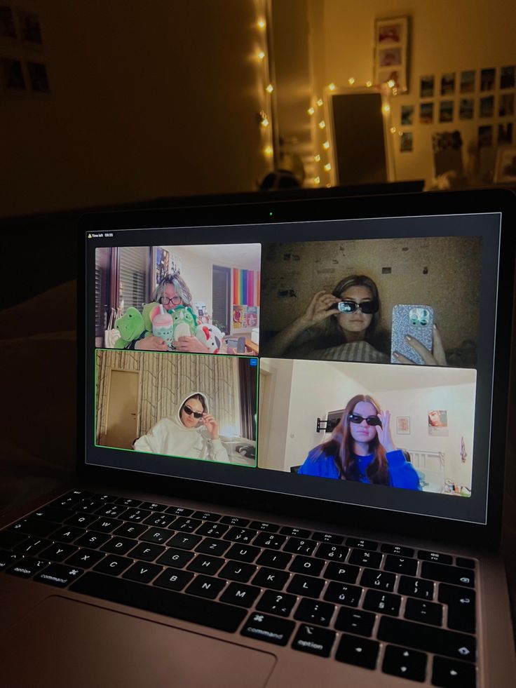 a laptop computer sitting on top of a desk with four people in the middle of it