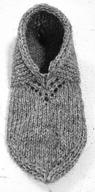 a gray knitted mitt sitting on top of a white surface