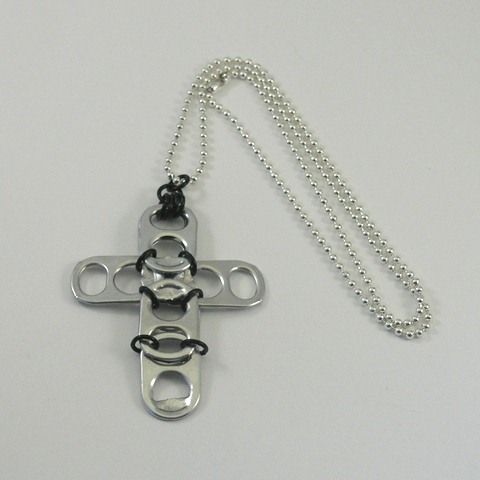 a metal cross with two chains hanging from it's sides on a white surface