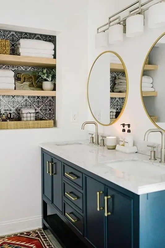 a bathroom with two sinks, mirrors and towels on the shelf above it is an area rug