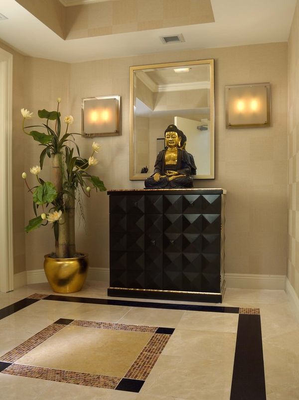 a large mirror sitting on top of a wooden cabinet next to a vase filled with flowers