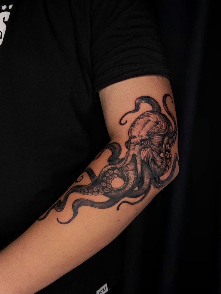 an octopus tattoo on the arm of a man