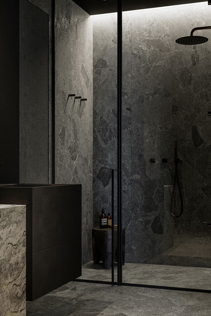 a bathroom with marble walls and flooring in the shower area is lit by recessed lighting