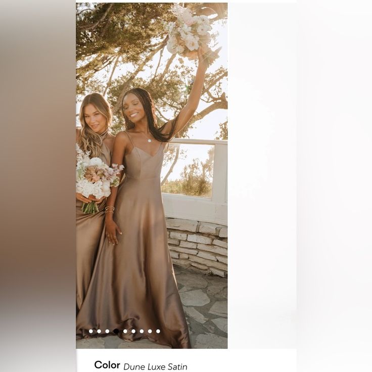 two beautiful women standing next to each other in front of a tree and flowers on the ground