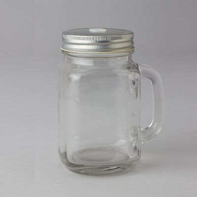 a glass jar with a metal lid on a white surface, it appears to be empty