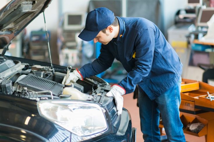 a man working on a car in a garage