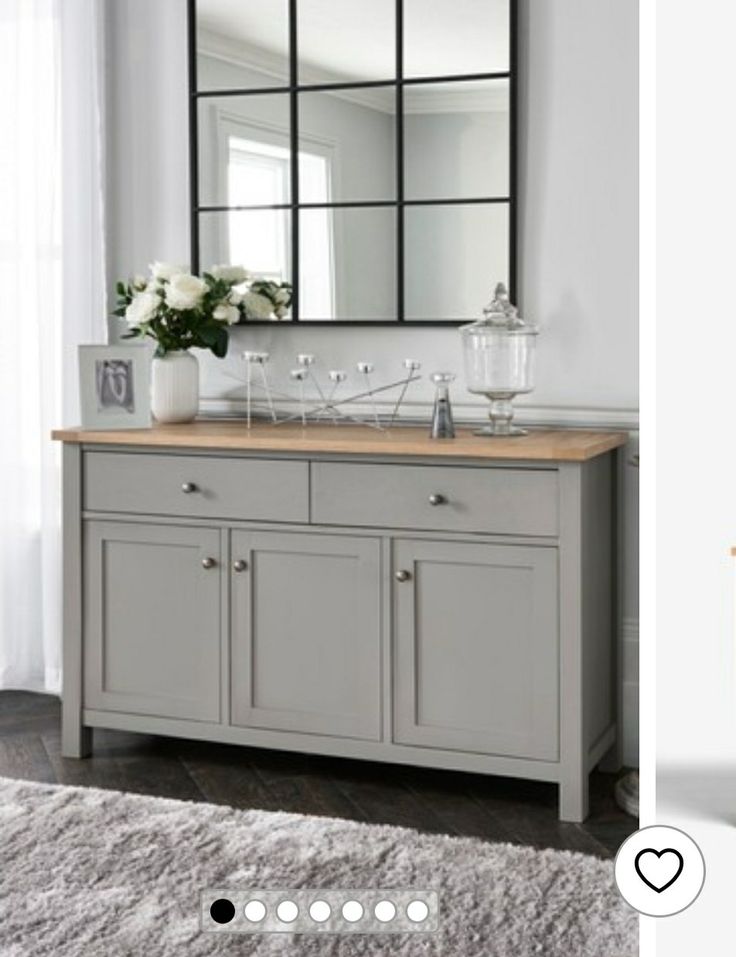 a gray dresser with mirrors and candles on top