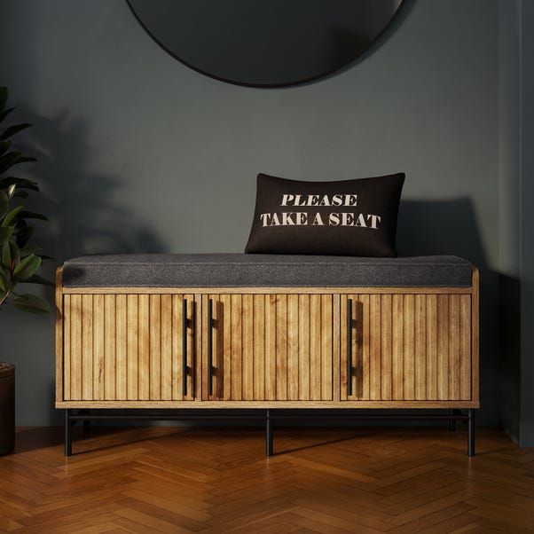 a wooden bench with a pillow on top of it next to a potted plant