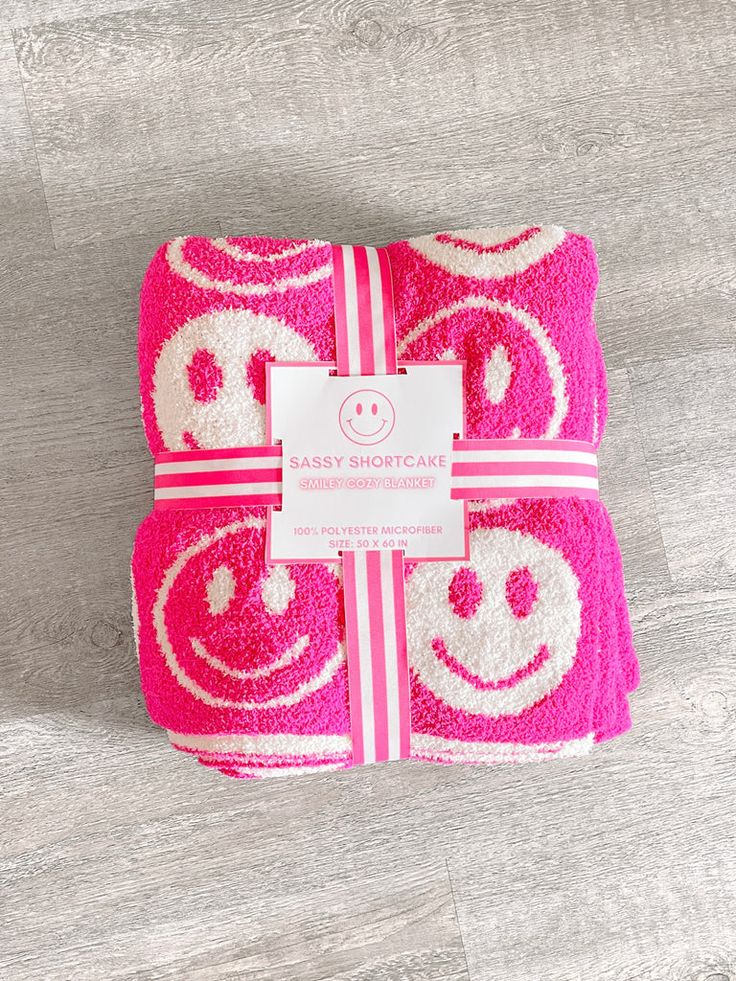 a towel wrapped in pink and white with a smiley face design on it's side