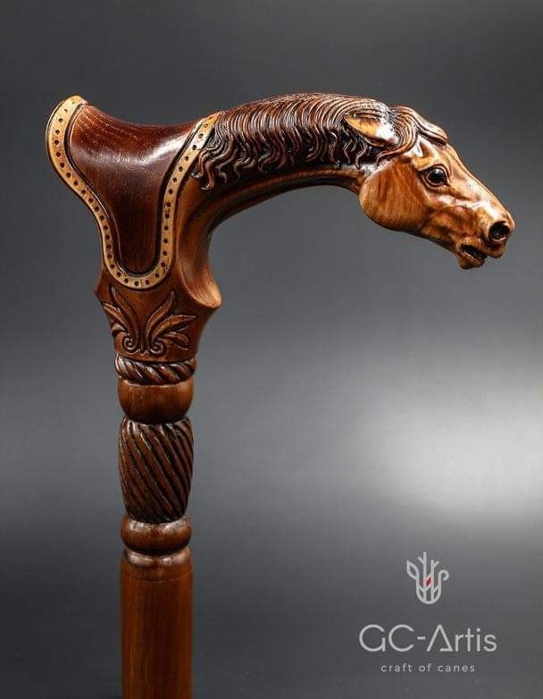 a carved wooden horse head on top of a wooden pole with an intricate carving pattern