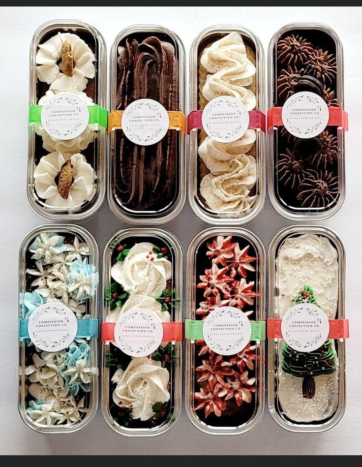 six tins filled with different types of desserts and flowers in each one container