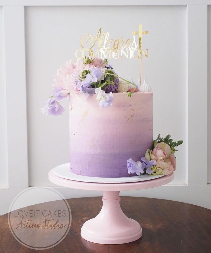 there is a cake with flowers on the top and a name sign above it that says sweet moments