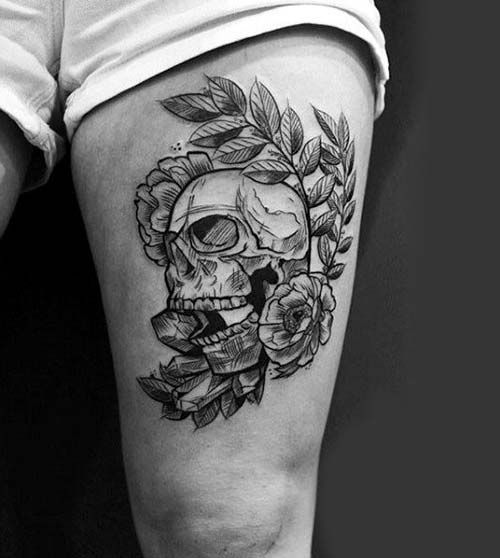 a woman's thigh with a skull and roses tattoo on it