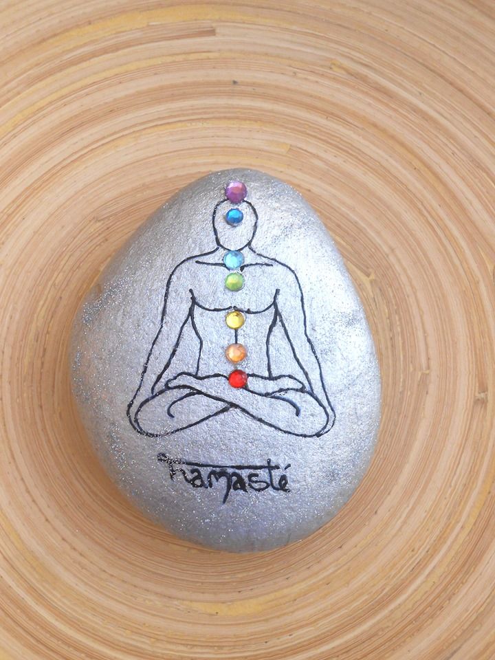 a rock with a drawing of a person sitting in a lotus position on top of it