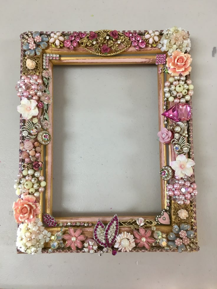 an ornate photo frame with flowers and pearls