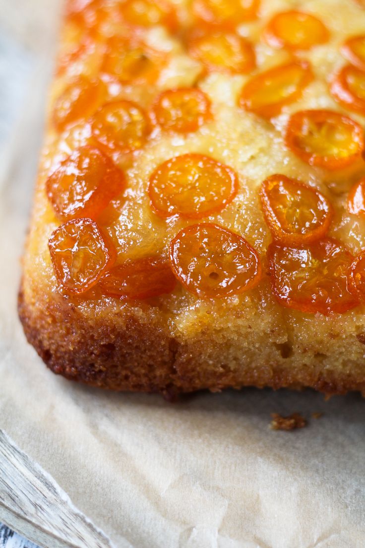 a close up of a slice of pizza on a piece of wax paper with orange toppings