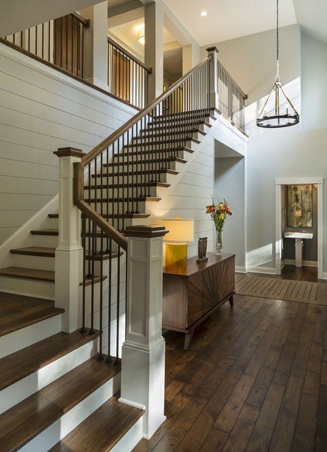 a staircase in a house with wood floors and white walls