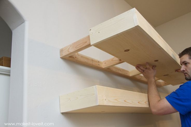 a man is working on some wooden shelves